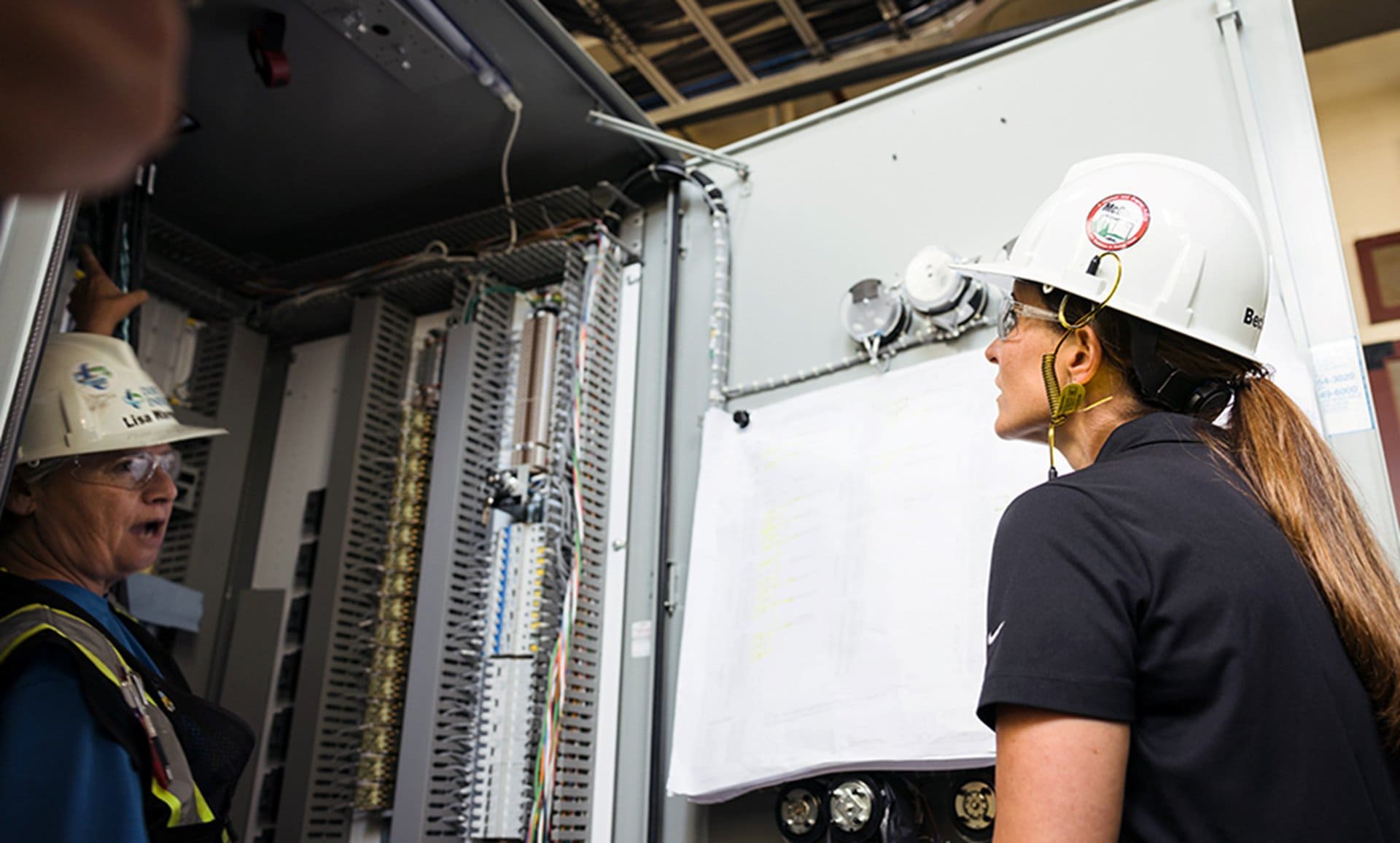 Lisa Warren, a Duke Energy implementation manager, shows Rollins inside a station control cabinet.